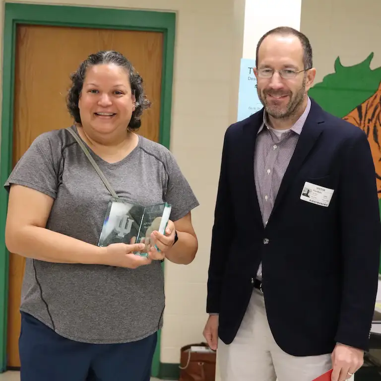 Ivelise Mendez-Perez and Troy Byler pose together with Ivelise's plaque.